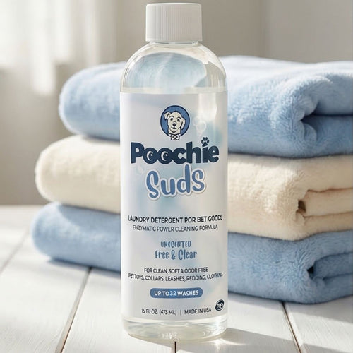 Bottle of Poochie Suds laundry detergent with folded towels in the background